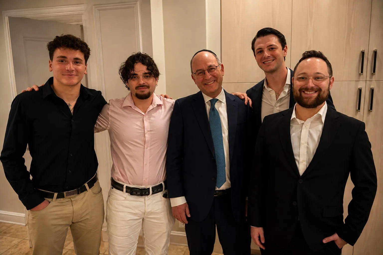 An executive standing with four students, arms around shoulders